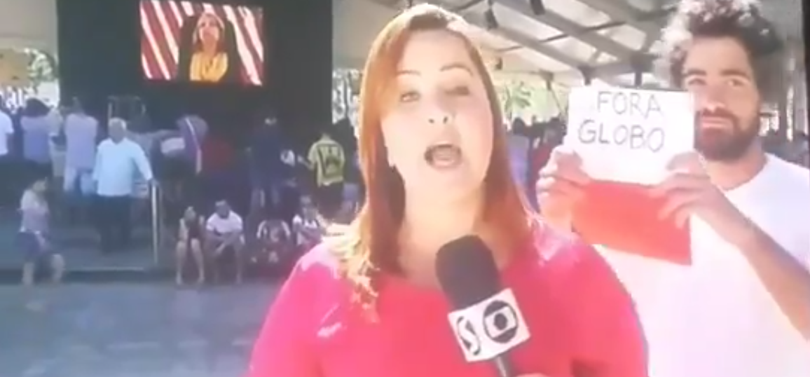 Manifestante protesta contra a Globo em reportagem ao vivo (Reprodução)