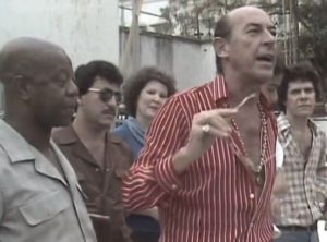 Célio (Raul Cortez) fala com integrantes de samba em Pai Herói