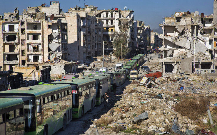Ônibus são estacionados para retirar civis e rebeldes da área Leste de Aleppo: cidade foi destruída em grande parte - KARAM AL-MASRI / AFP (Reprodução: O Globo)