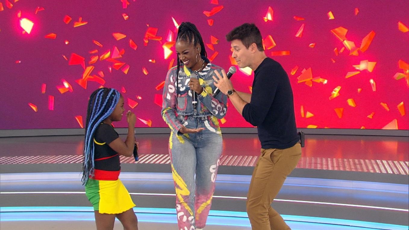 Cantora Iza ajuda pequena fã no palco do programa Hora do Faro