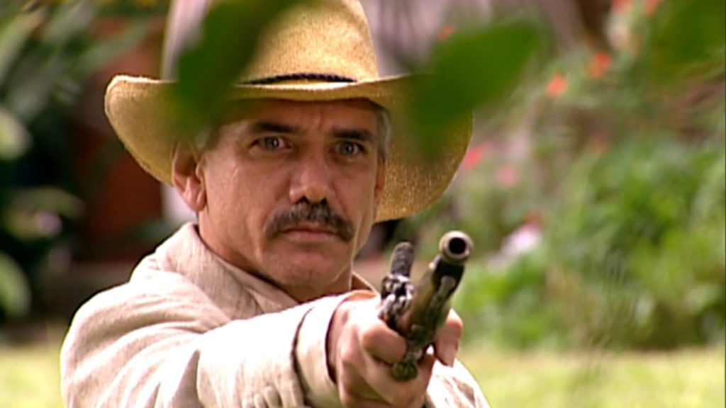Miguel (Jackson Antunes) aponta arma para Martinho (Cláudio Curi) e Raimundo (Rômulo Delduque) em A Escrava Isaura