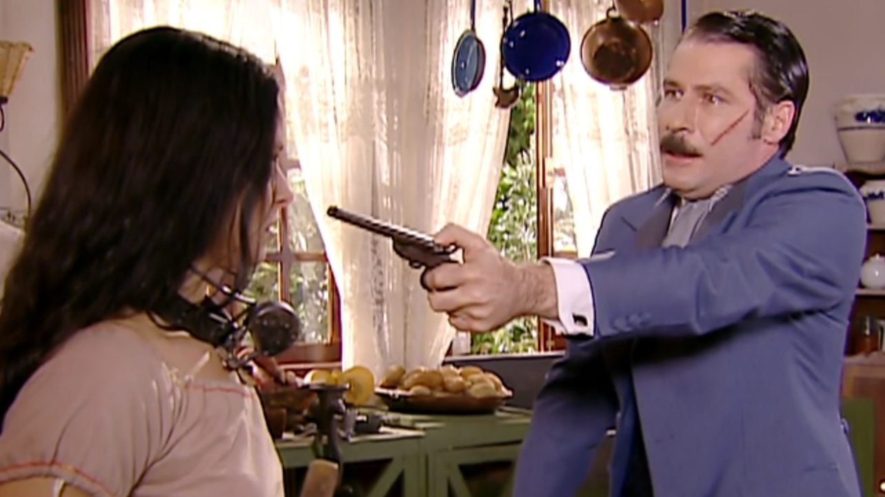 Leôncio (Leopoldo Pacheco) apontando uma arma para Isaura (Bianca Rinaldi) em A Escrava Isaura