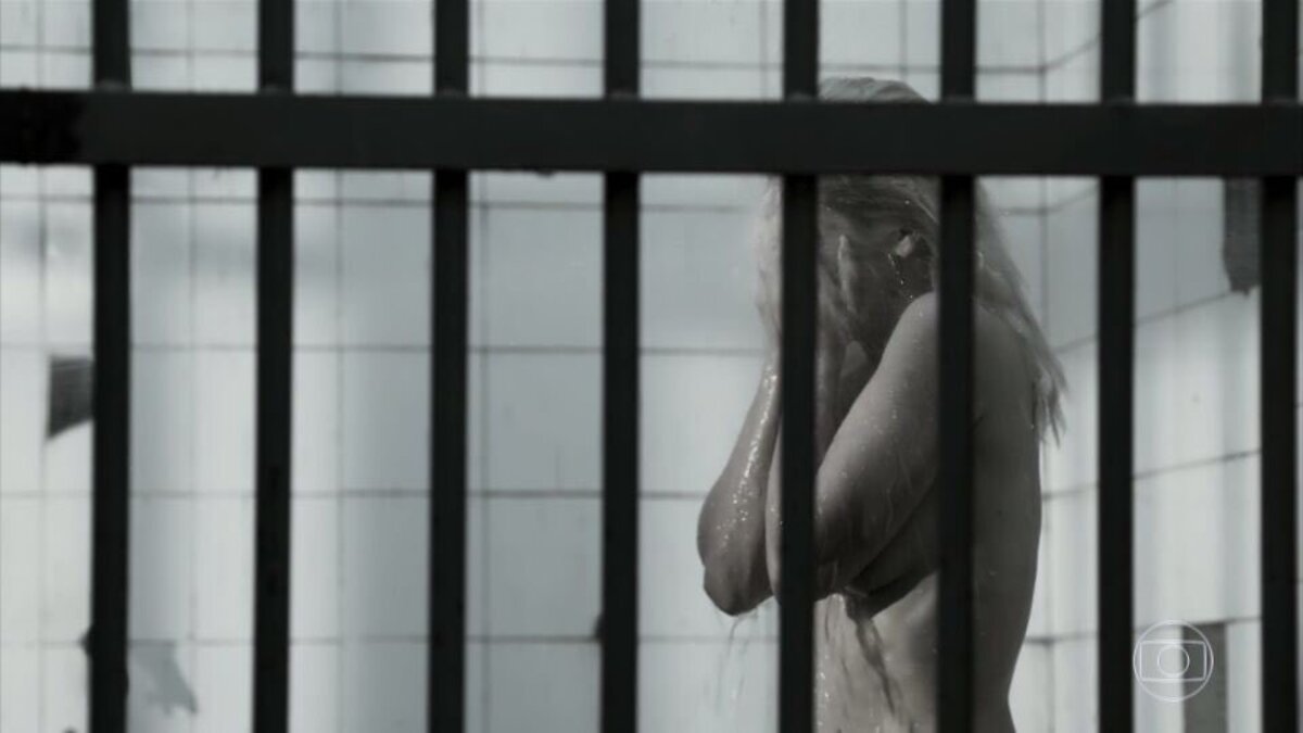 Sandra (Flavia Alessandra) toma banho nua na prisão