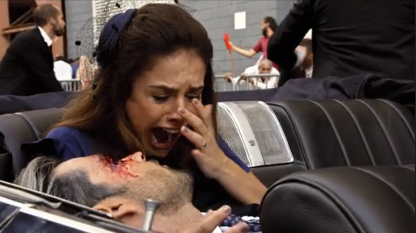 Ricardo (Sérgio Marone) baleado nos braços de Isabela (Paloma Bernardi) em Apocalipse