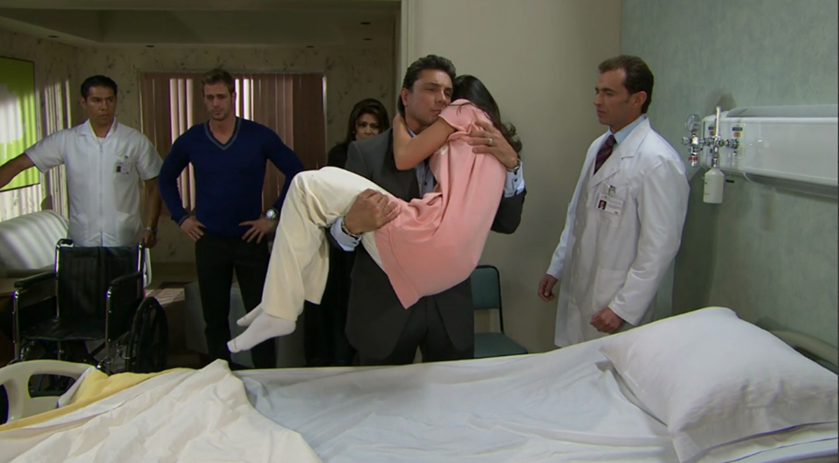 Fernanda é carregada por Osvaldo após se recusar a ir embora de cadeira de rodas (Reprodução: Televisa S.A.)