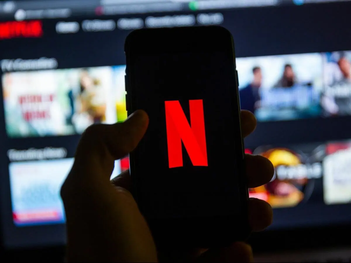 Imagem de celular com logo da Netflix; crise ativada