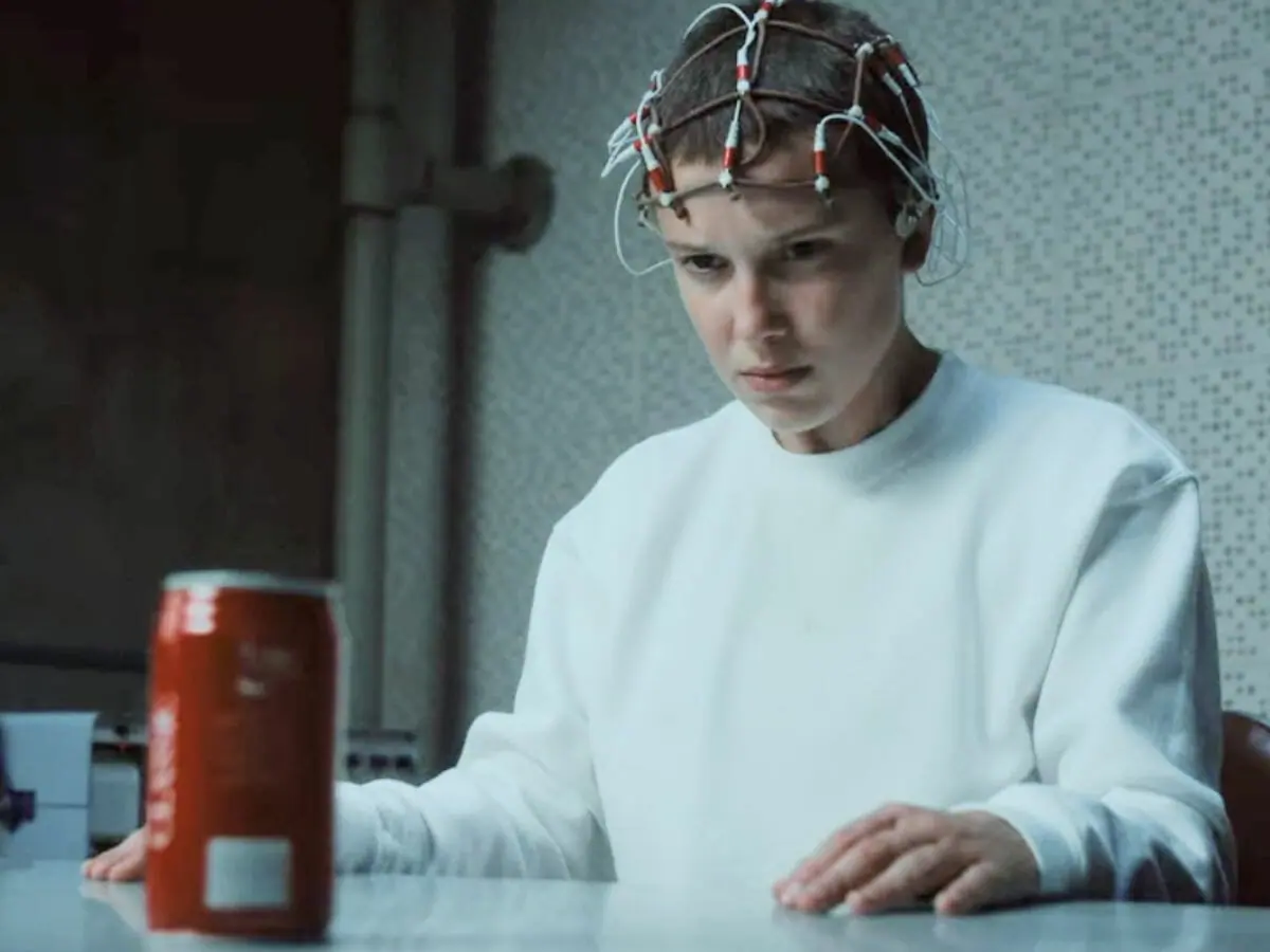 Eleven (Millie Bobby Brown) tenta amassar uma lata de Coca-Cola em Stranger Things 4